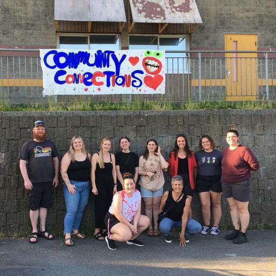 A group of people under a sign that reads Community Connections